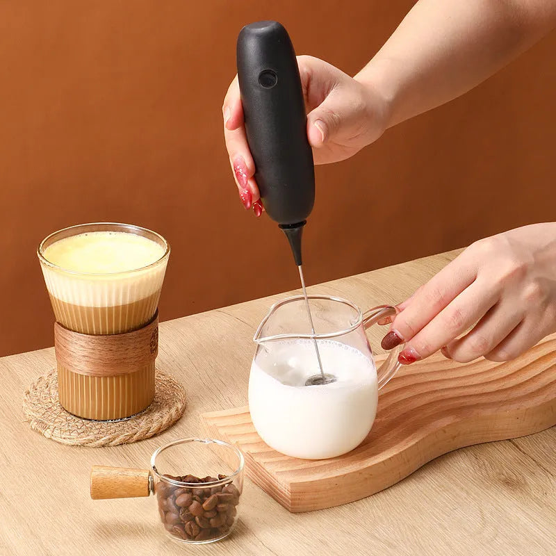 Black and white hand-held electric milk frother with blender function for coffee drinks