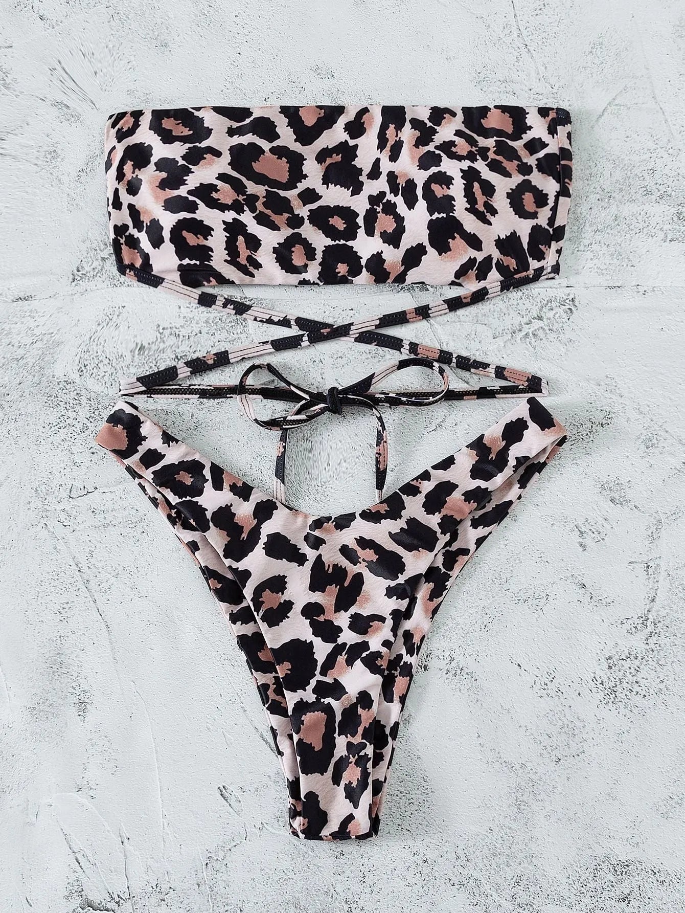 Leopard print bandeau split bikini swimsuit with removable chest pads on woman at beach