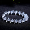 Women's adjustable white crystal bracelet with a pyramid bead and ruyi charm, shown on a wrist.