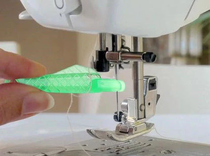 Small fish design needle threader for sewing machines in green, metal and plastic construction