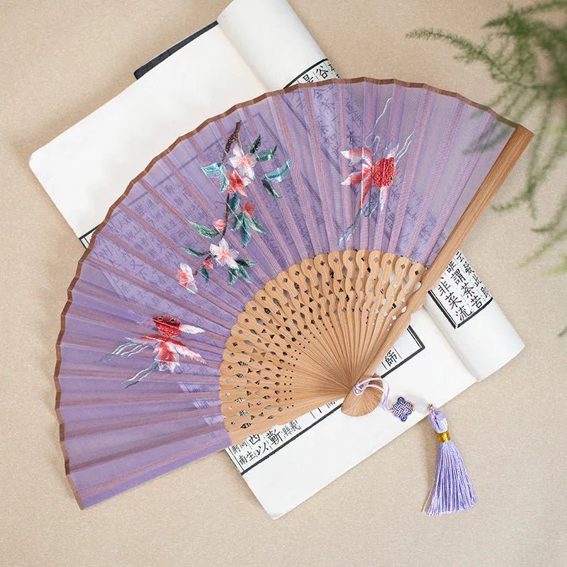 Bamboo folding fan with silk embroidery showing traditional Chinese patterns