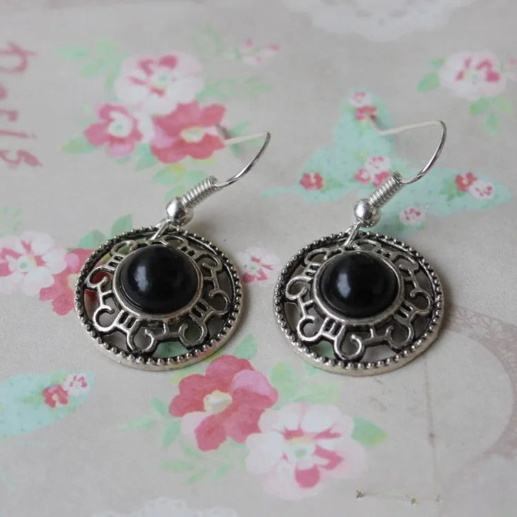 Handmade geometric flower disk earrings in Tibetan silver and turquoise with ethnic patterns.