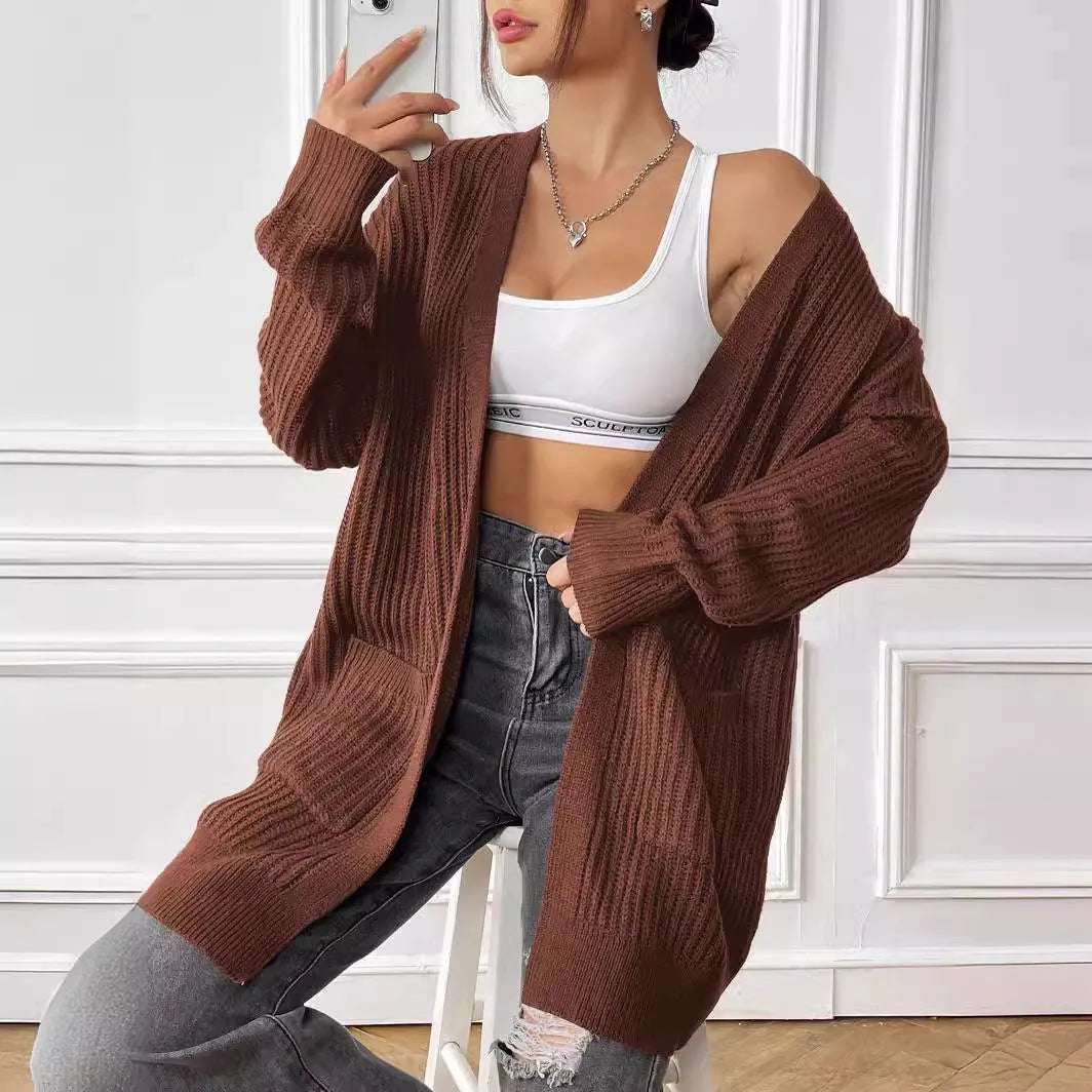 Women's dark green loose-fit acrylic cardigan sweater with double pockets and long sleeves.