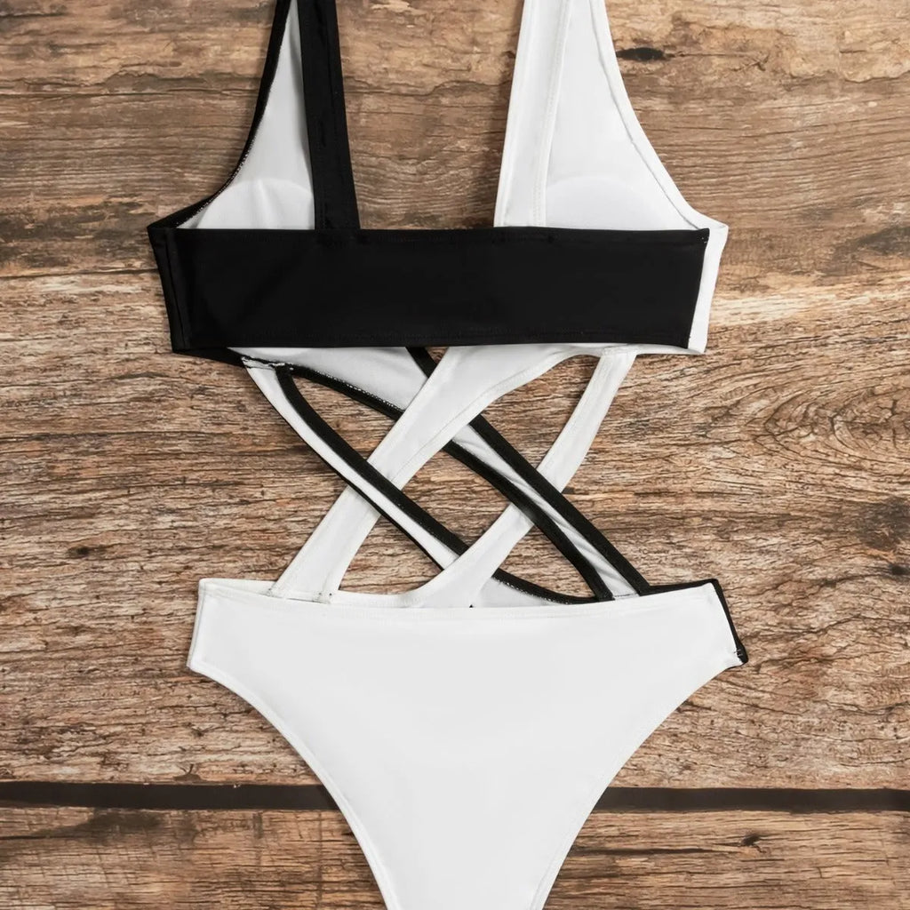 White women's one-piece swimsuit with colour-block and hollow-out design on a mannequin.