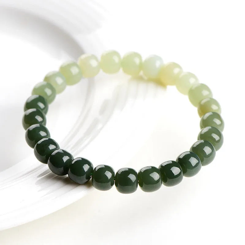 Natural Hetian jade bracelet with clear water gradient colour on wrist, showing polished beads.