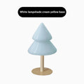 Colourful Christmas tree table lamp with glass lampshade and wrought iron base on a side table