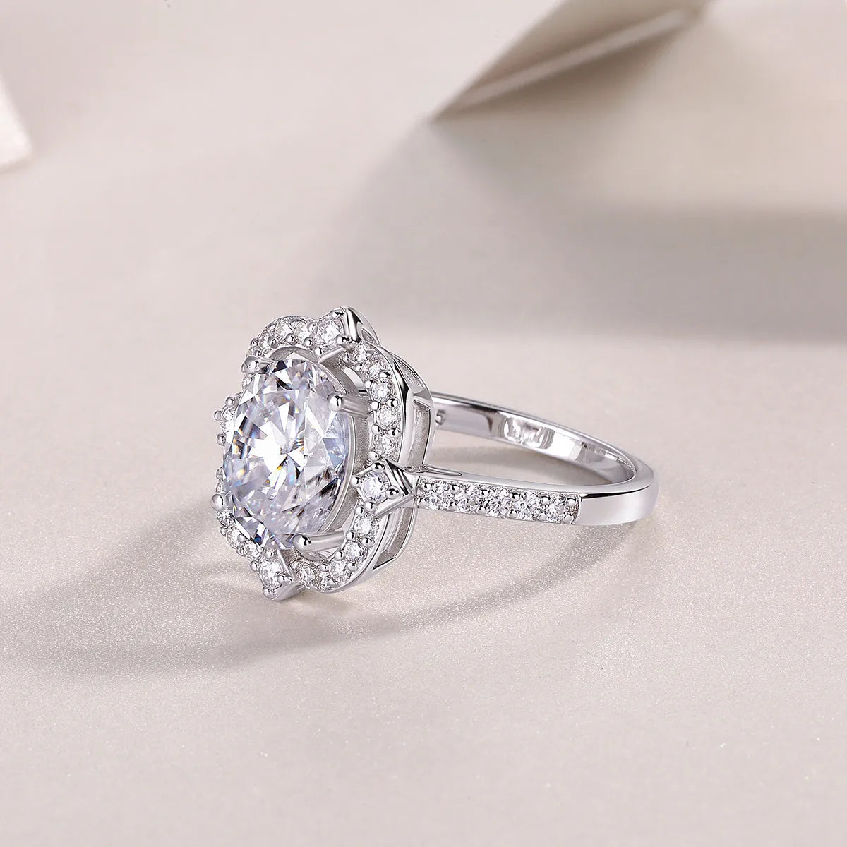 Egg-shaped moissanite ring set with S925 silver and platinum plating on a white surface