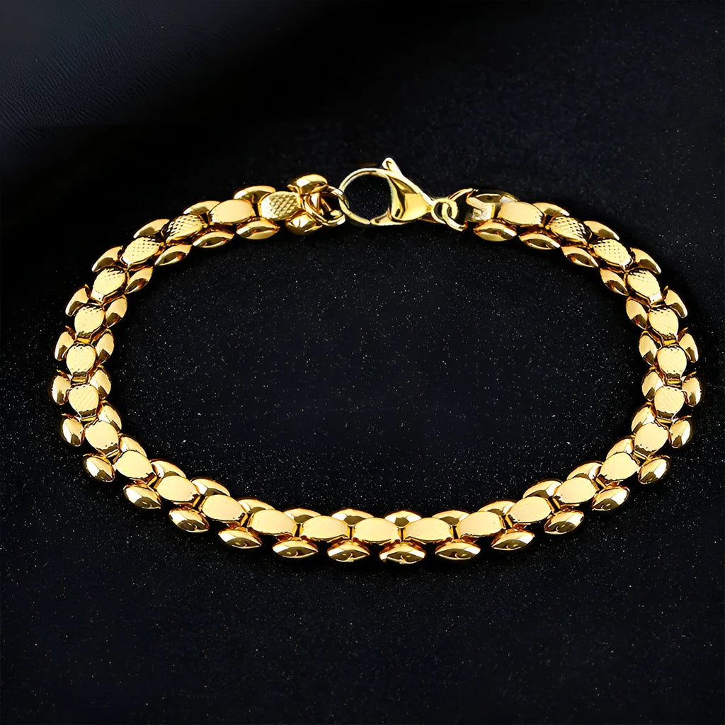 L254 Gold iron bracelet laid flat on a surface, showing its metallic finish and simple design.