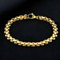 L254 Gold iron bracelet laid flat on a surface, showing its metallic finish and simple design.