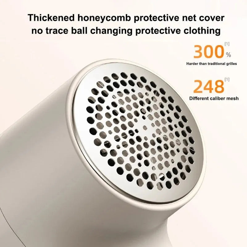 White electric lint remover with LED display and USB port on a fabric background.