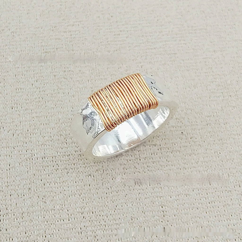 Silver golden geometric coil copper ring for men and women on a grey background.