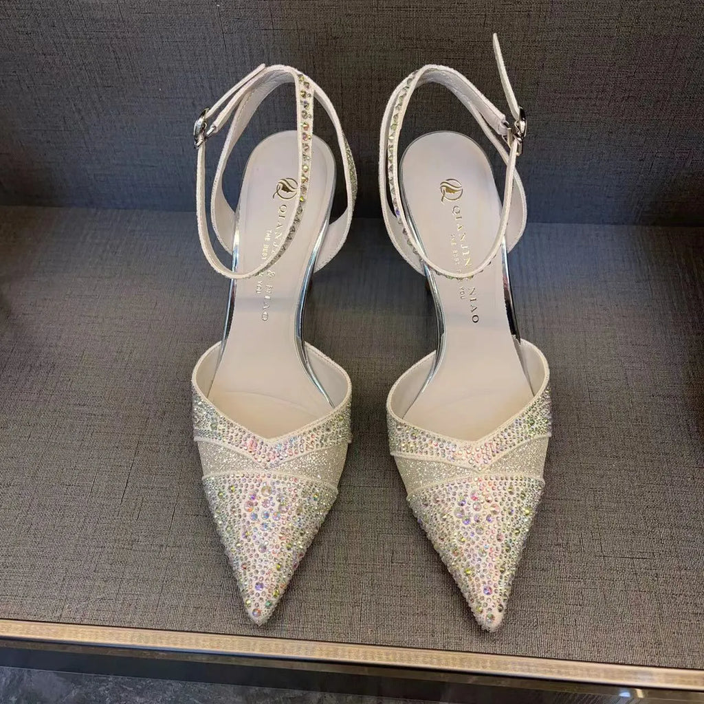 Women's black hollow stiletto heel pump shoe with pointed toe and red sole on a white background.