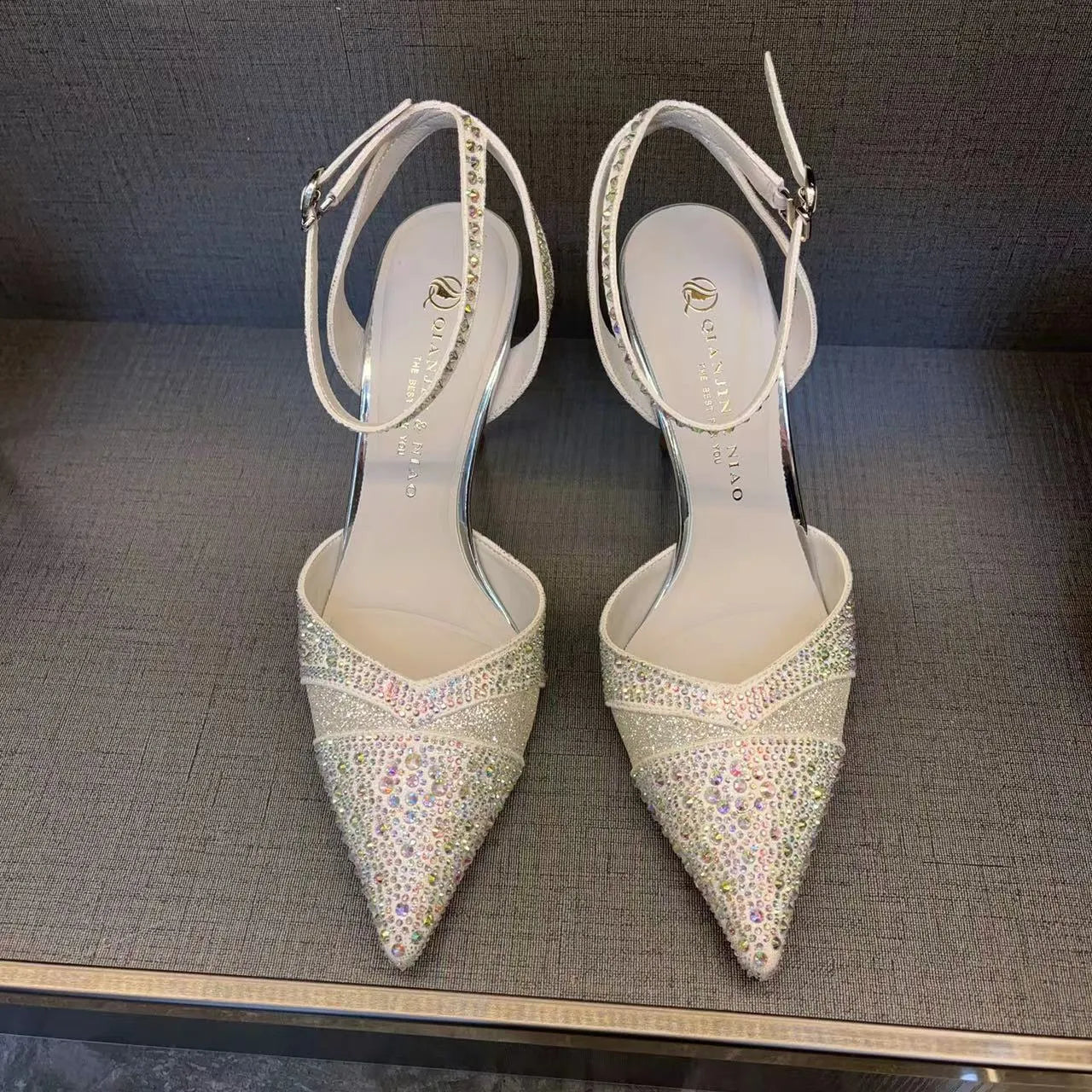 Women's black hollow stiletto heel pump shoe with pointed toe and red sole on a white background.