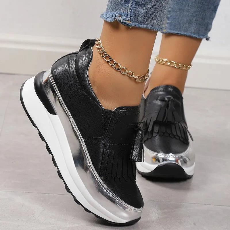 Black women's casual platform shoes with tassel detail and a distinctive English muffin wedge heel.