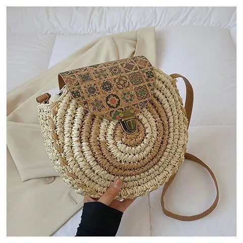 Round straw woven crossbody bag in beige, 25cm diameter, with adjustable shoulder strap, displayed on a neutral background