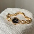 Women's quartz watch with alloy bracelet and pointer display, gold strap black surface