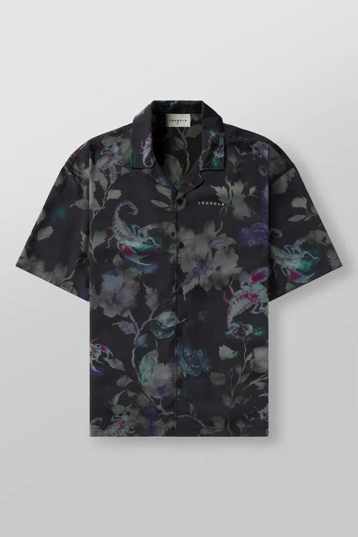 Man wearing a loose-fitting grey short-sleeve top with a floral print design.