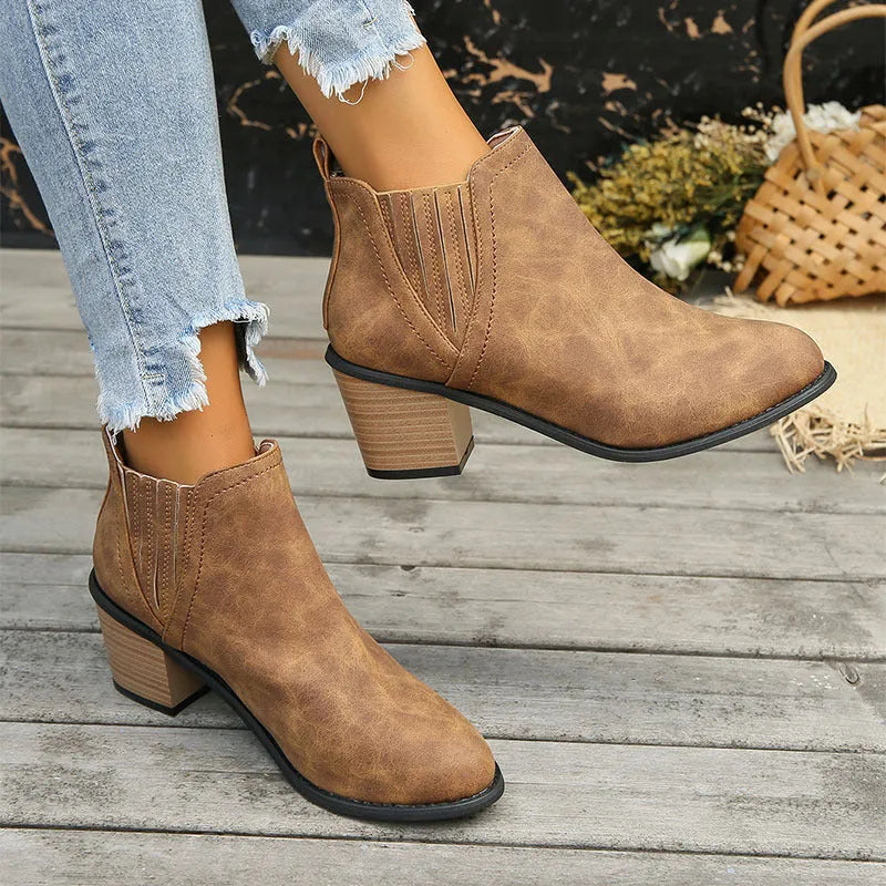 Black women's ankle boots with a pointed toe and thick square heel on a rubber sole.