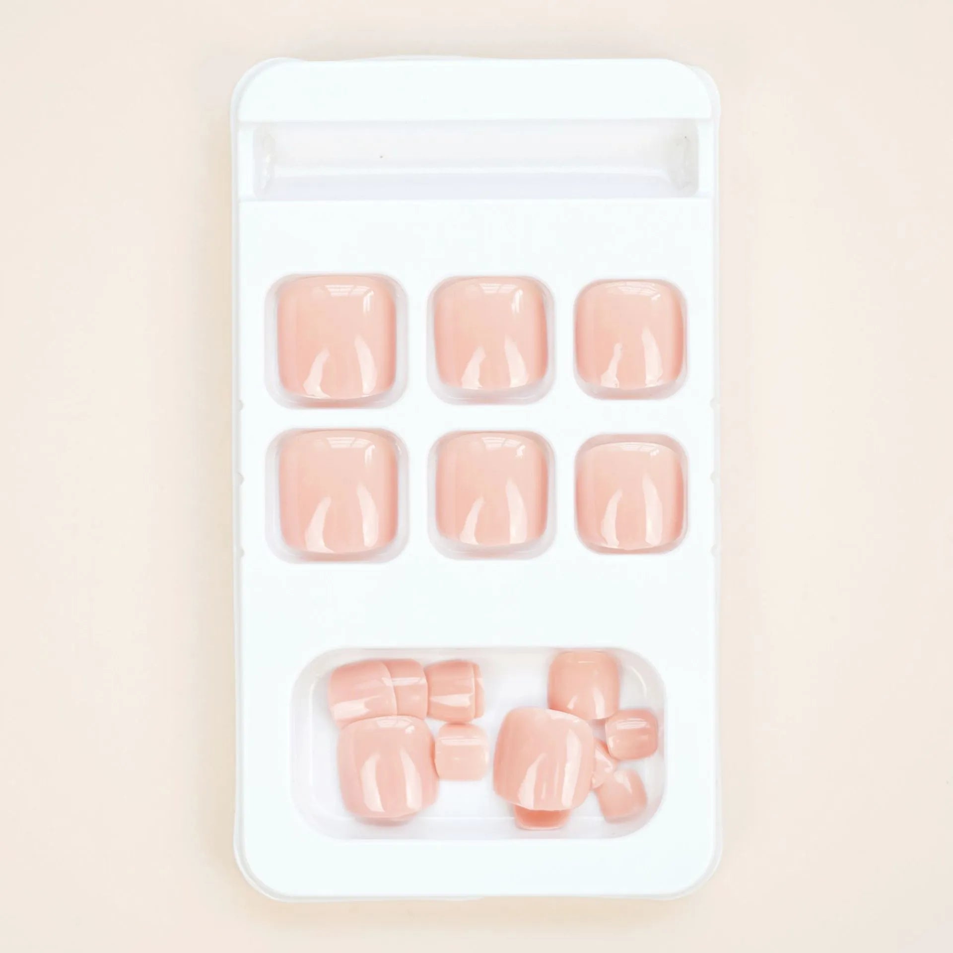 Finished plastic toenail stickers in skin colour with glue bottle, presented on a card.