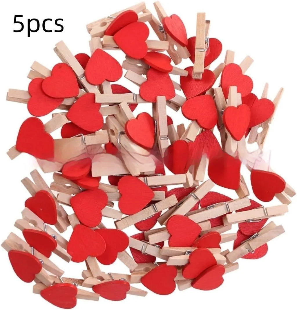Set of five small red, pink, and white solid wood heart-shaped clips on a surface.