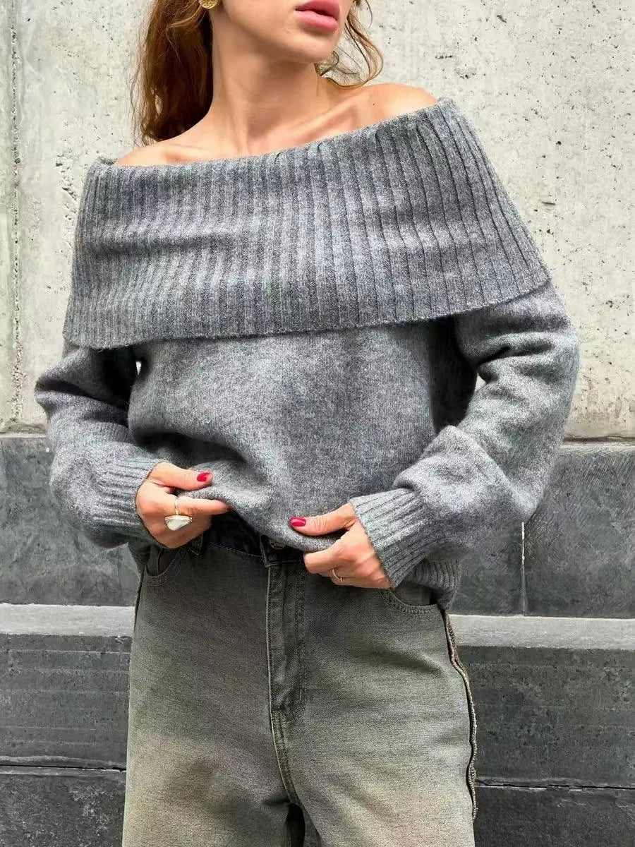 Grey off-the-shoulder acrylic sweater with a textured 3D pattern on a hanger.