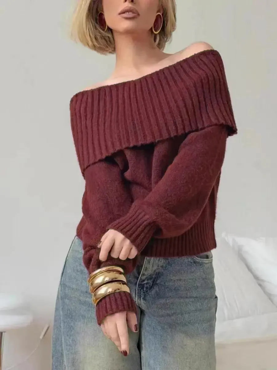 Grey off-the-shoulder acrylic sweater with a textured 3D pattern on a hanger.