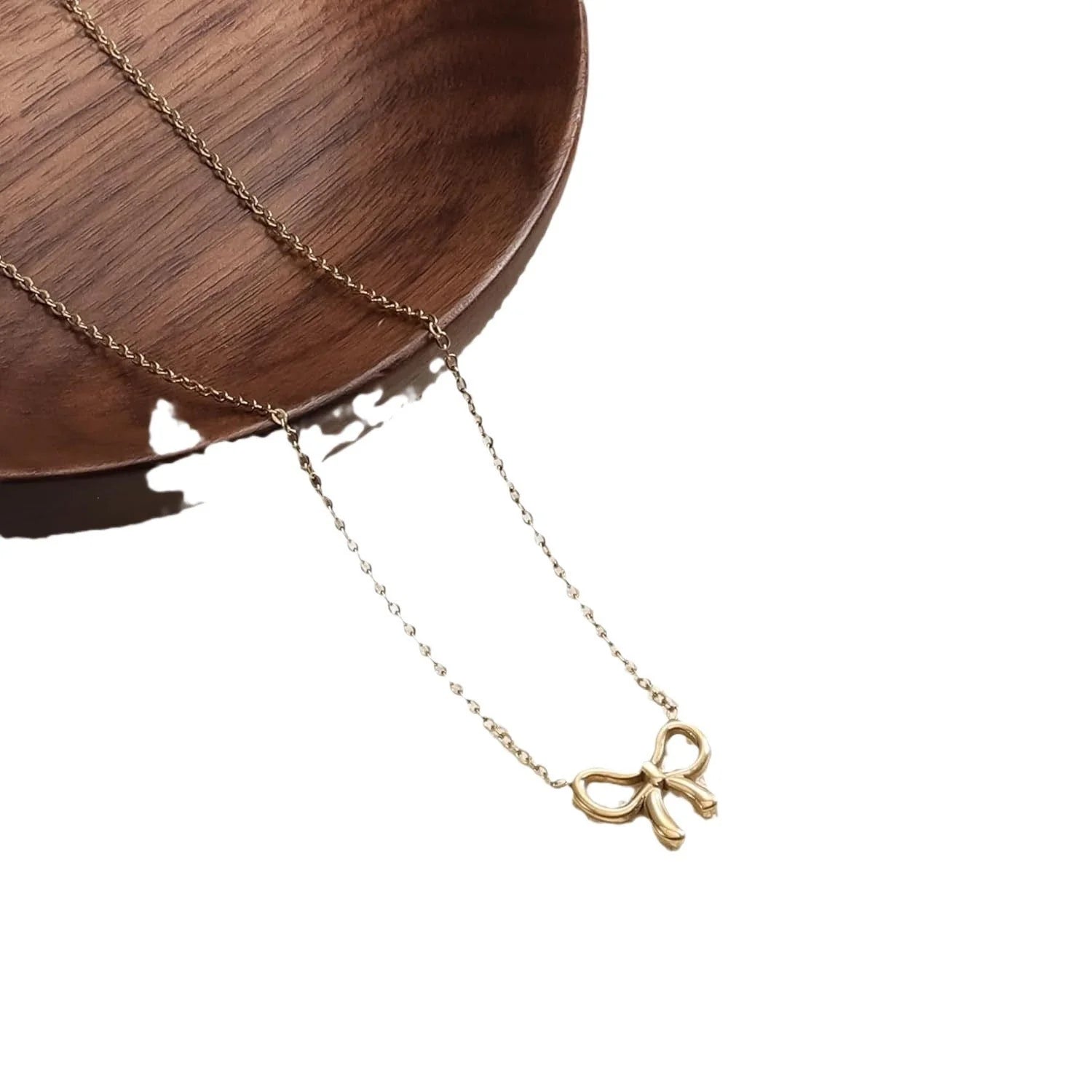 Double layer pearl choker with bow pendant in gold and silver options