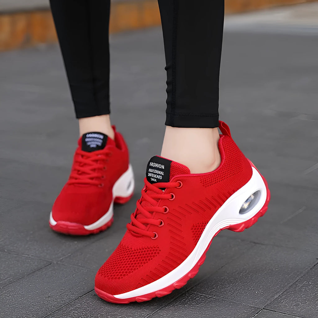 Red and black women's low top lace-up mesh sneakers with a round toe and mid heel.
