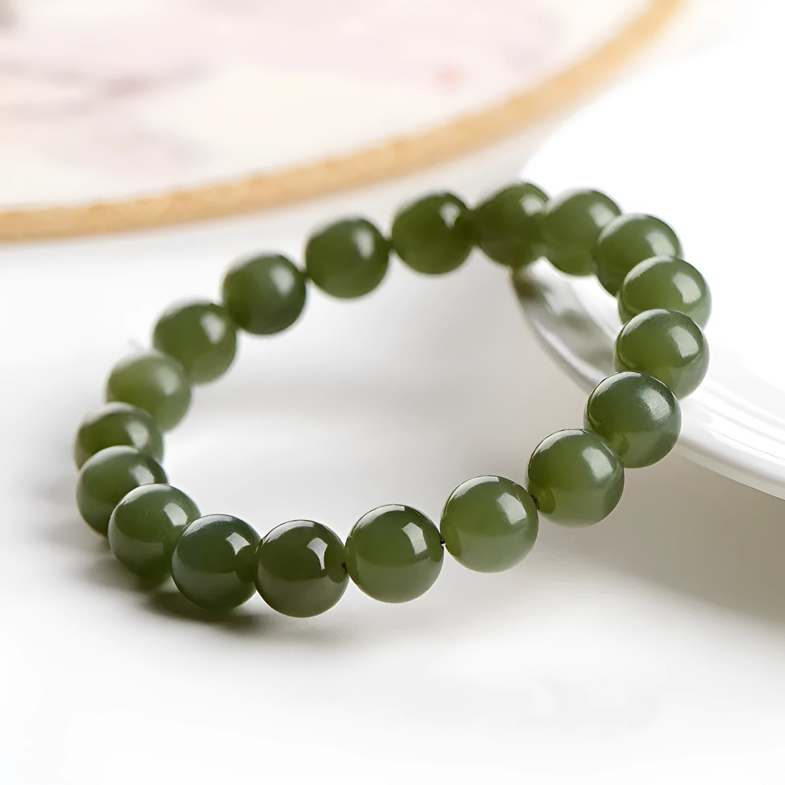 Polished Hetian jade beaded bracelet on a wrist, showing ice-like clear colour tones and spherical beads.