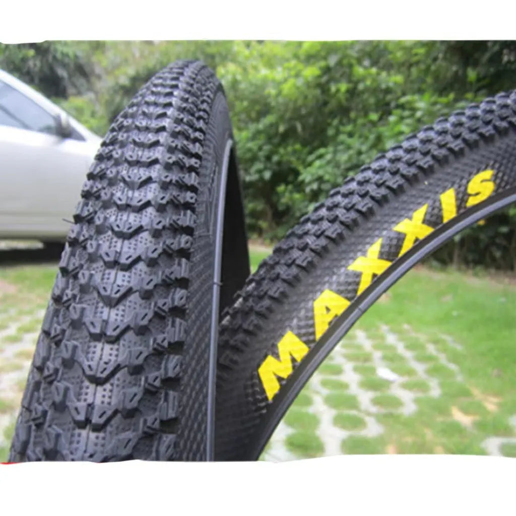 Ultralight puncture-proof mountain bike tyre in multiple sizes on a grey background.