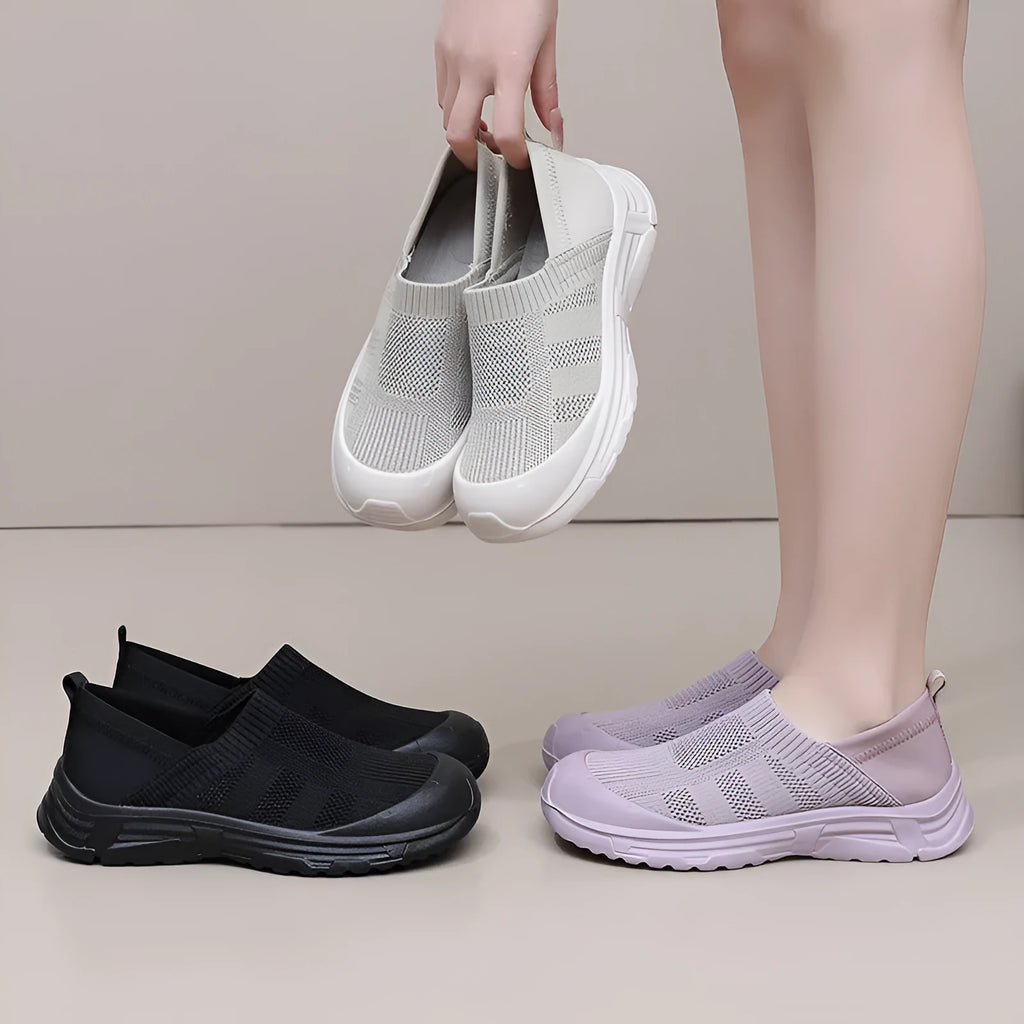 Women's black oversleeve shoes with round toe and soft flat PVC sole.