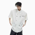 Men's loose-fit short-sleeved casual shirt with lapel collar and decorative button detail.
