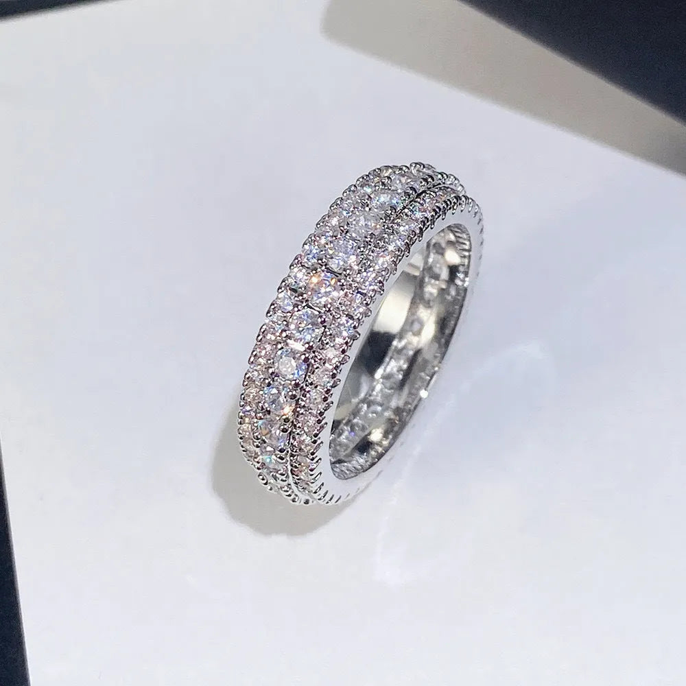 Geometric triangle zircon inlay ring in white gold, yellow gold, and white and black finishes on a copper band.