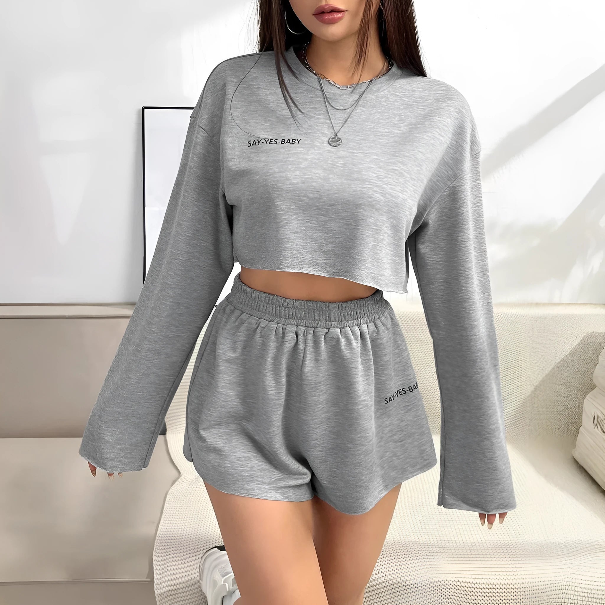 Women's grey long-sleeved t-shirt and shorts matching polyester set laid flat showing both pieces