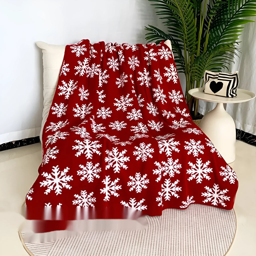 Personalised acrylic Christmas blanket with snowflake pattern draped over a sofa.