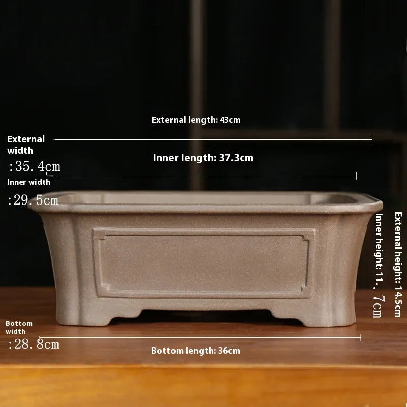 Antique-style rectangular purple sand bonsai pot on a floor.