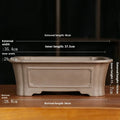 Antique-style rectangular purple sand bonsai pot on a floor.