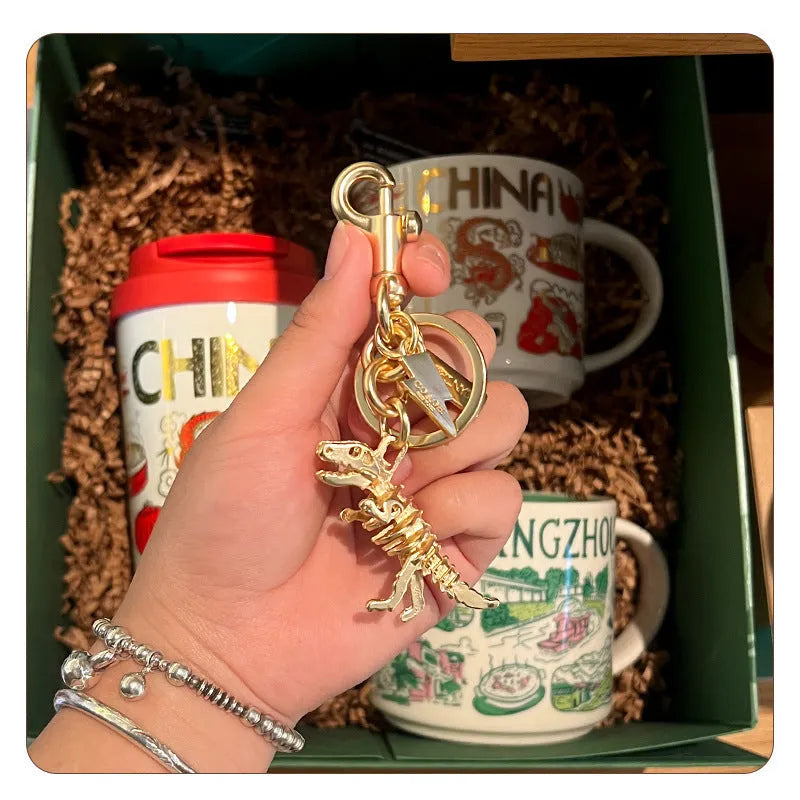 Golden bone dragon zinc alloy dinosaur keychain on a neutral background, showing retro animal pattern