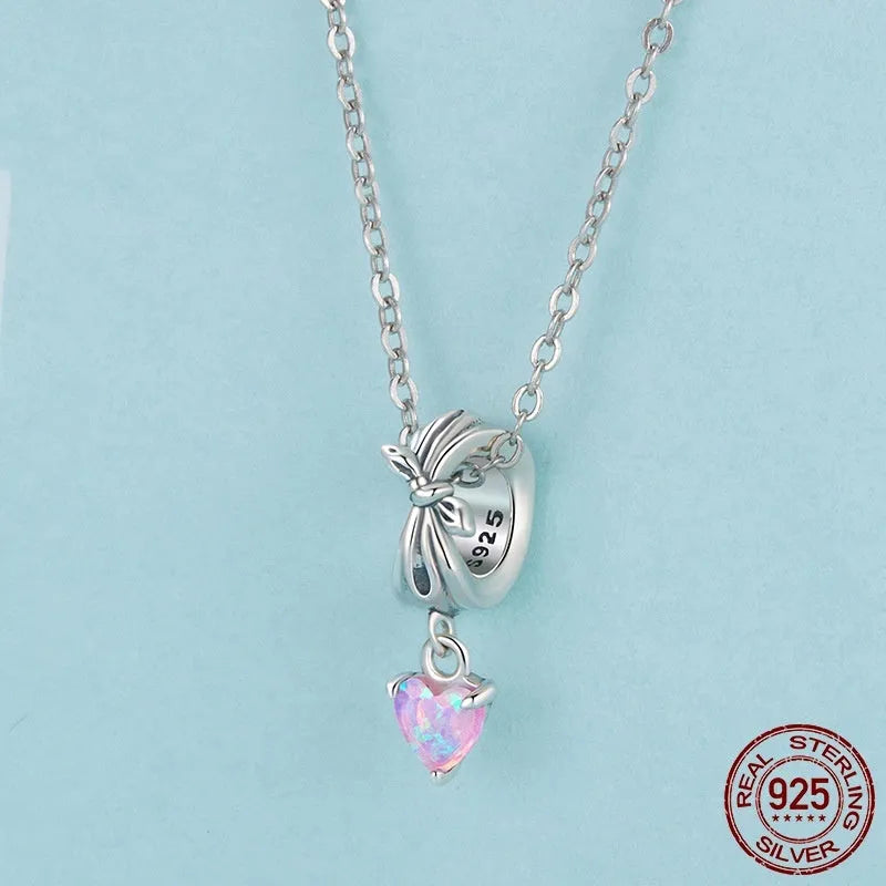 S925 sterling silver pendant with opal bow and loving heart motif, 1.6cm height, on white background