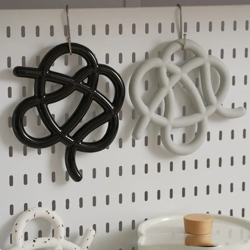 Ceramic heat proof mat in an irregular shape on a kitchen table, shown in a solid colour.