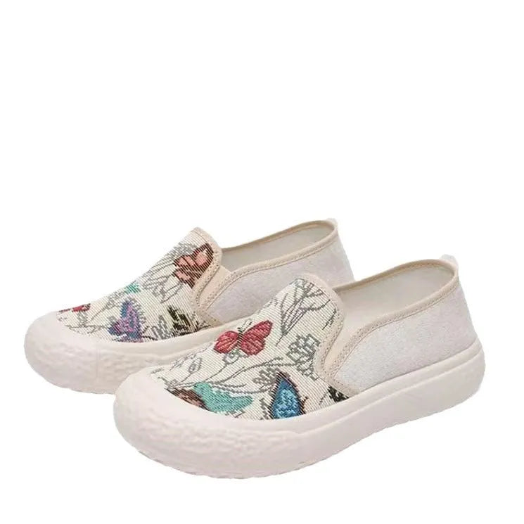 Women's canvas slip-on shoes with plastic soles in black and white colours showing sewing thread decoration