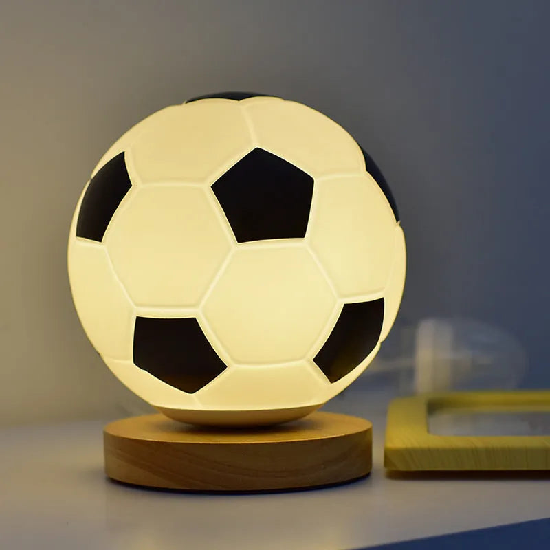 Football LED small night lamp with glass shade and remote control on a bedside table