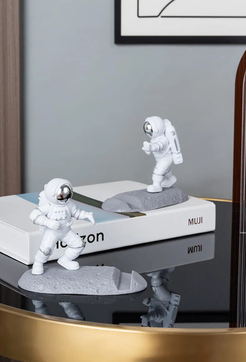 Plastic astronaut decoration mobile phone holder in blue colour on a desk