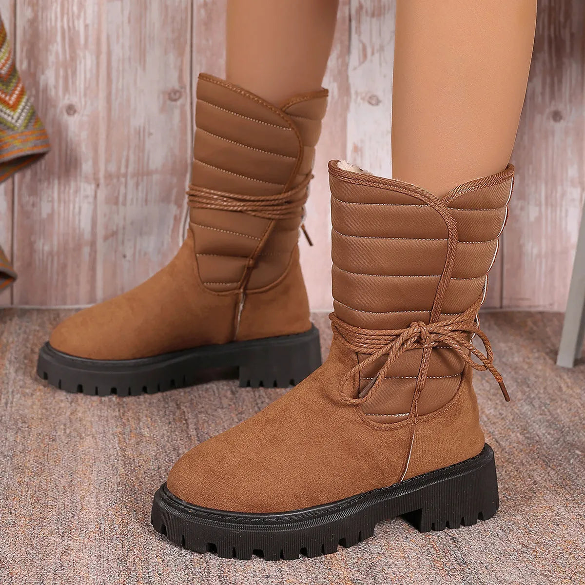 Black women's chunky heel snow boots with lace-up design and suede upper on a rubber sole