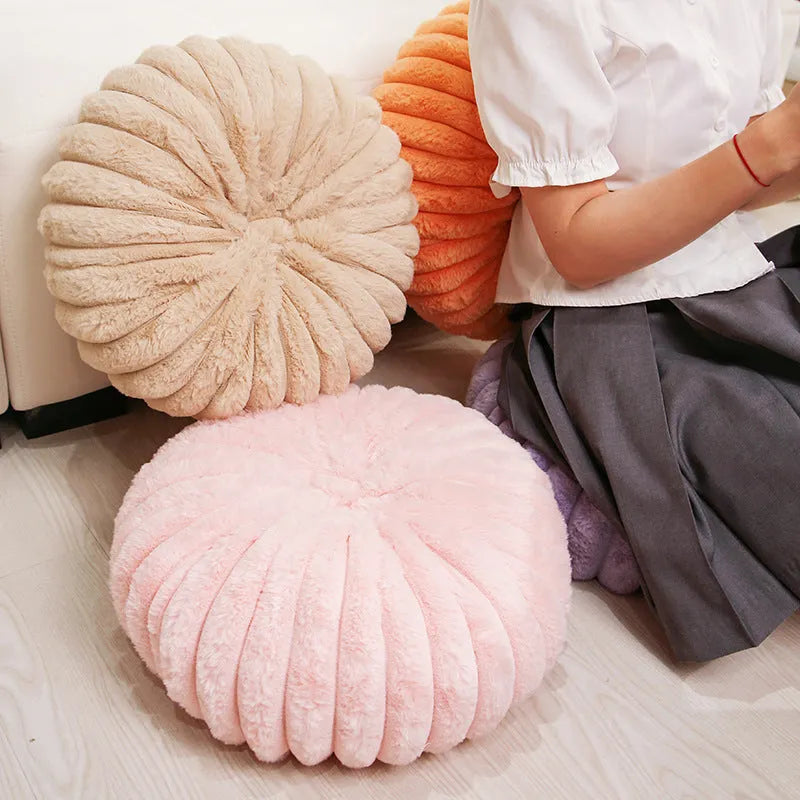 Pumpkin shaped seat cushion in khaki with short plush cover, 35x35x15cm, next to a window