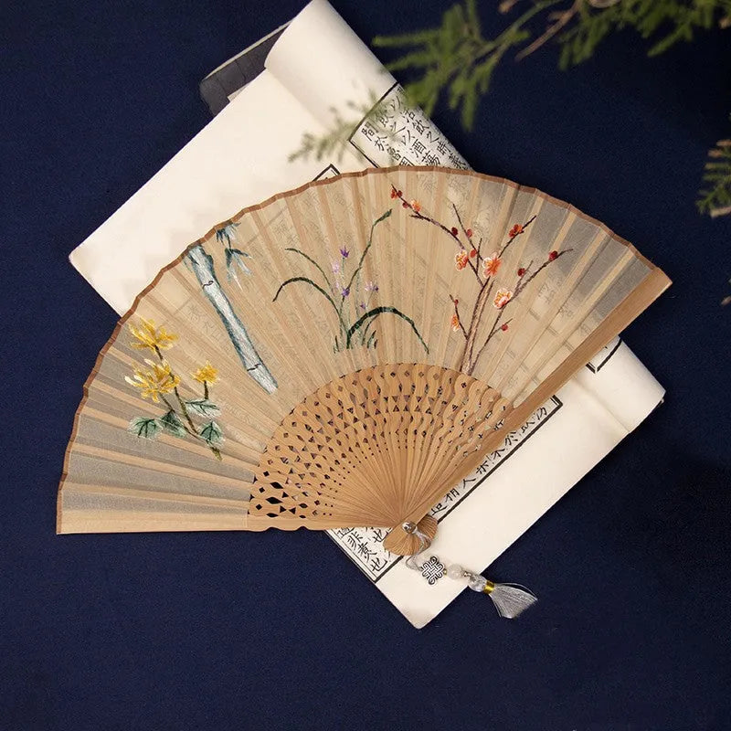 Bamboo folding fan with silk embroidery showing traditional Chinese patterns