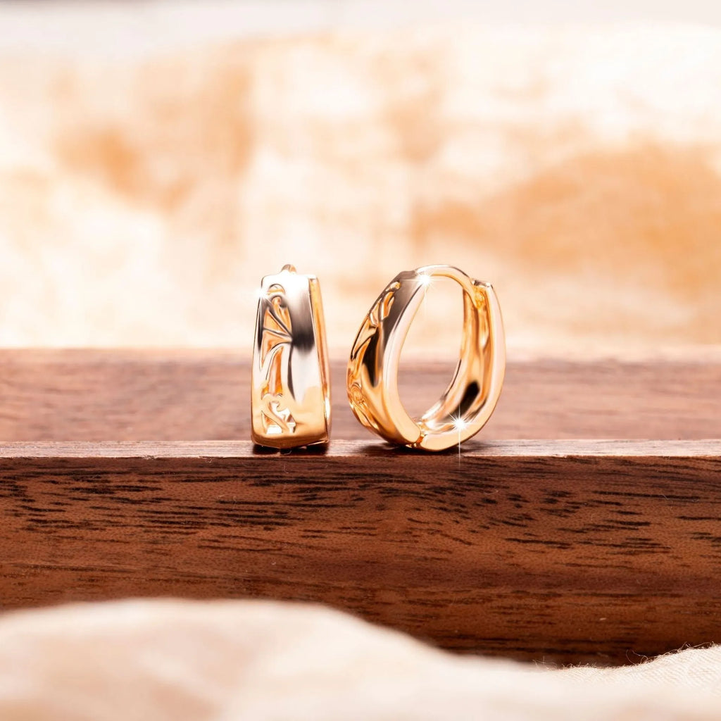 Rose gold copper hollow carved U-shaped women's earrings on a neutral background