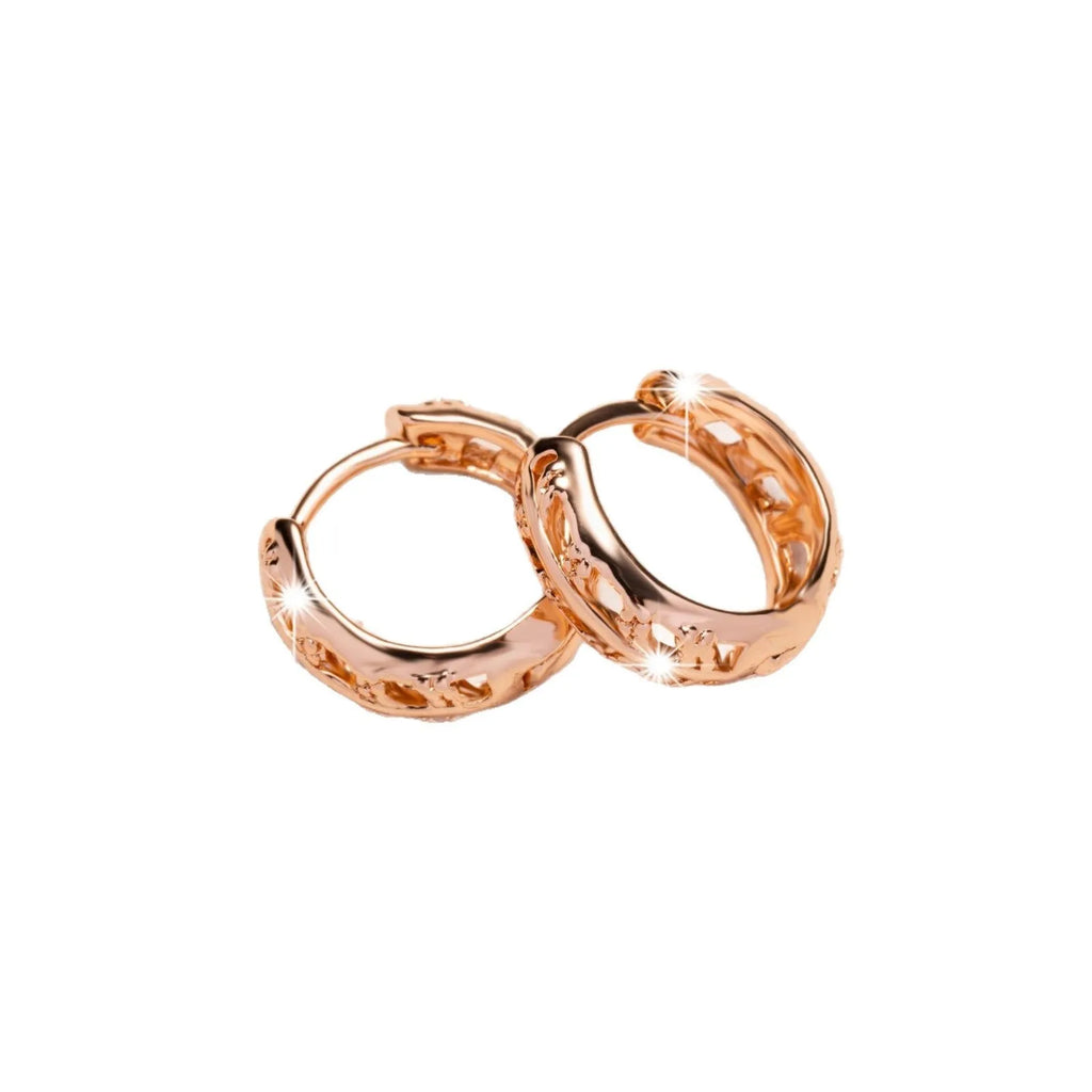 Copper earrings with hollowed-out leaf and heart design in rose gold colour.