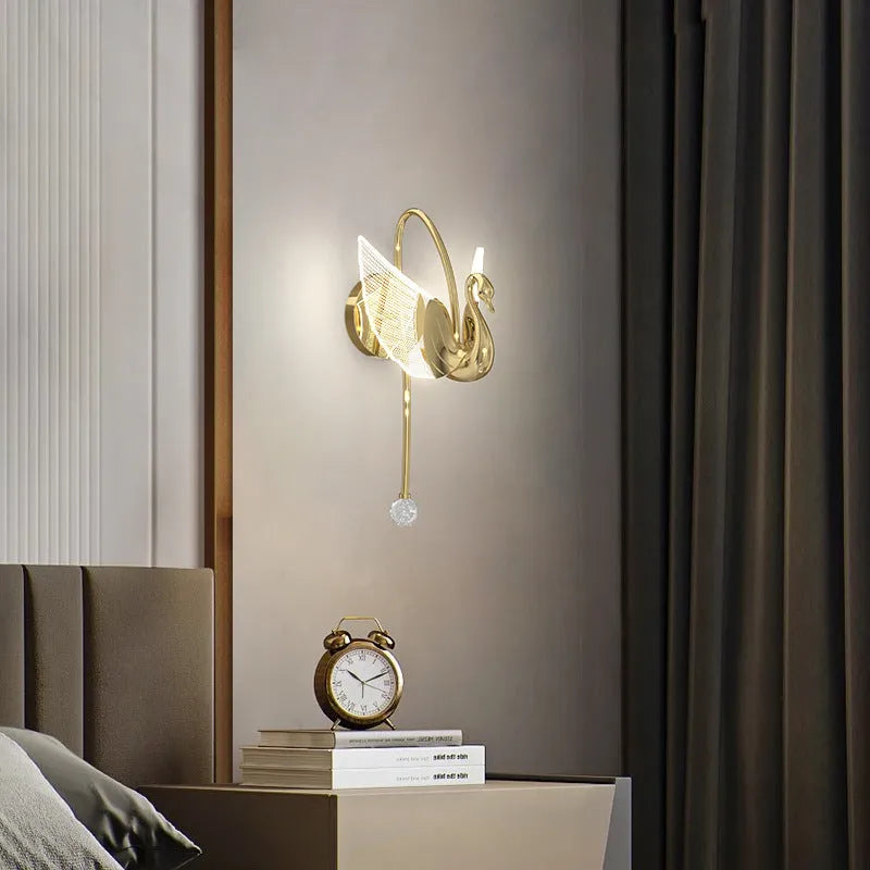 Modern minimalist gold swan-shaped wall lamp with an acrylic shade and LED light.