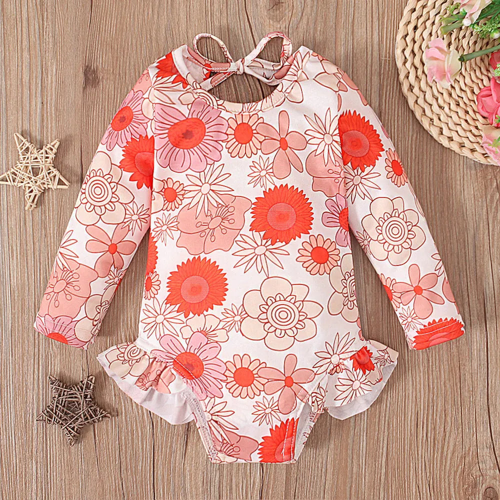 Girl's floral print swimsuit with crew neckline and open back design in orange colour